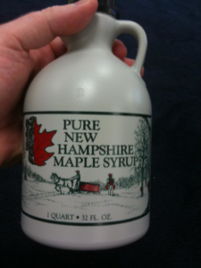 Image of a Pure New Hampshire Maple Syrup 1 Quart bottle in someone's hand.
